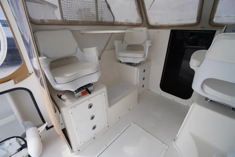 Slide: The Image of 2018 May-Craft 2700 Pilot XL interior with white seating and storage compartments. - 15