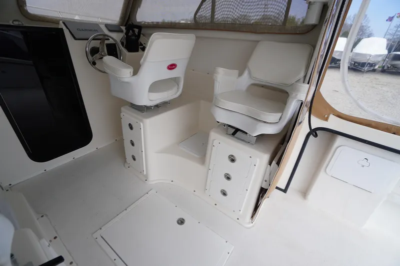 Slide: The Image of Interior of 2018 May-Craft 2700 Pilot XL boat with dual white captain chairs. - 16