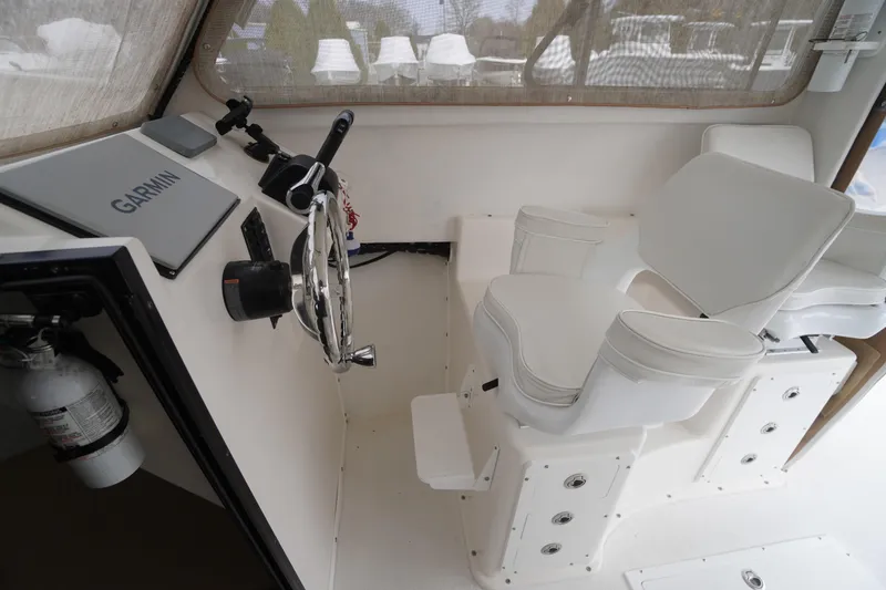 Slide: The Image of 2018 May-Craft 2700 Pilot XL boat cockpit with Garmin navigation and white captain's chair. - 17