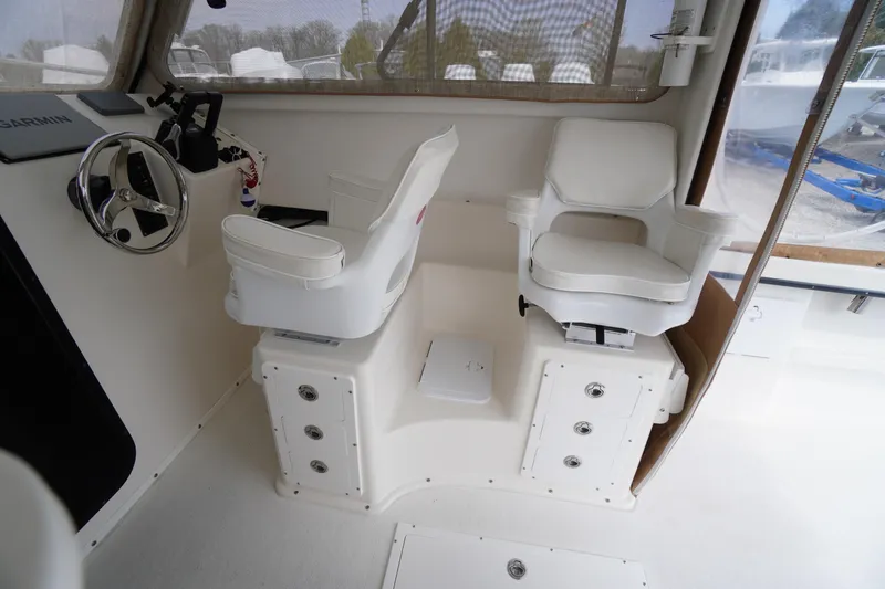 Slide: The Image of Interior of 2018 May-Craft 2700 Pilot XL boat with dual white captain chairs. - 20