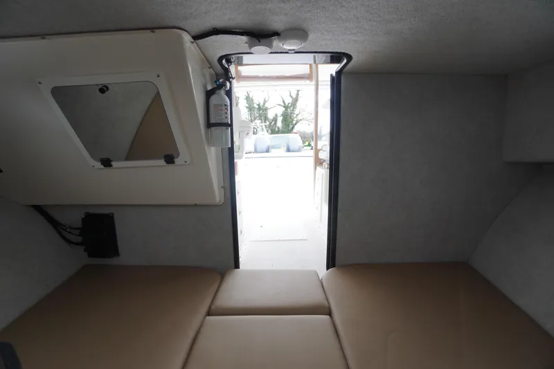 Slide: The Image of Interior cabin view of 2018 May-Craft 2700 Pilot XL boat, featuring cushioned seating. - 28