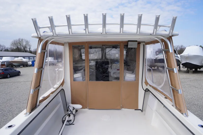 Slide: The Image of 2018 May-Craft 2700 Pilot XL boat with enclosed cockpit and ladder, parked outdoors. - 3