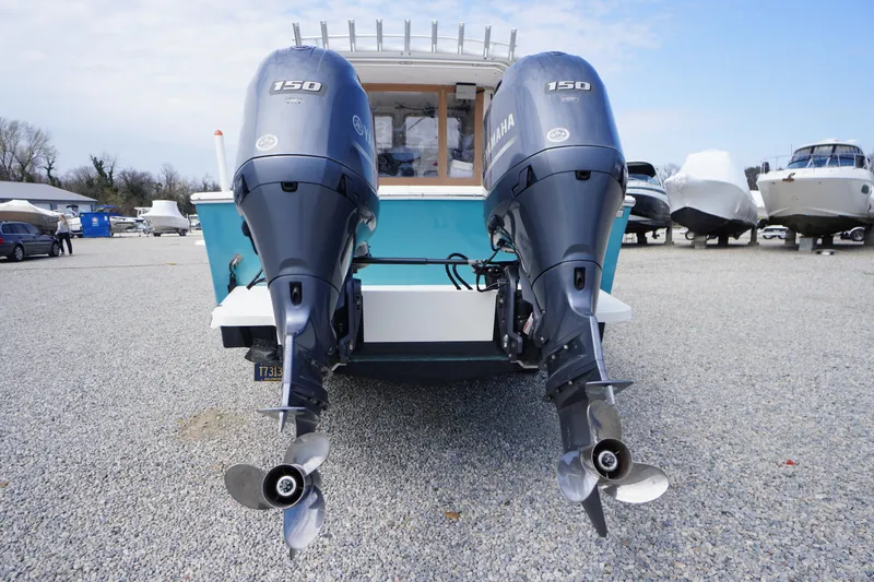 Slide: The Image of 2018 May-Craft 2700 Pilot XL with twin Yamaha 150 engines, parked on gravel. - 36