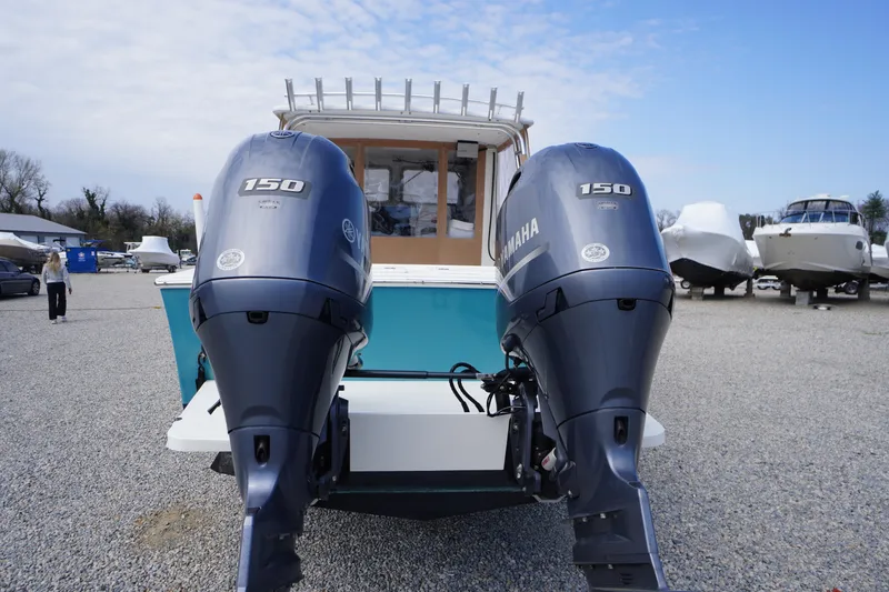 Slide: The Image of 2018 May-Craft 2700 Pilot XL with dual Yamaha 150 engines, parked on gravel. - 37