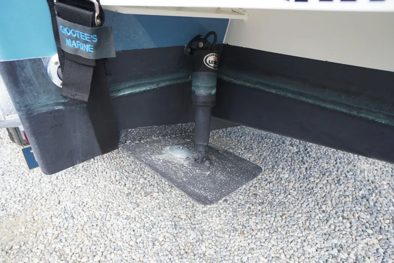 Slide: The Image of 2018 May-Craft 2700 Pilot XL boat trim tab detail on gravel surface. - 38
