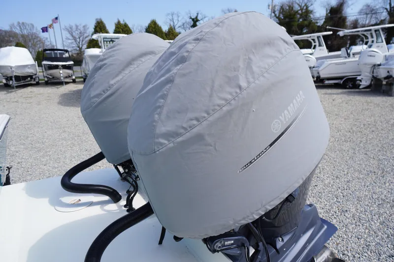 Slide: The Image of Twin Yamaha outboard motors on a 2018 May-Craft 2700 Pilot XL, covered and parked outdoors. - 42