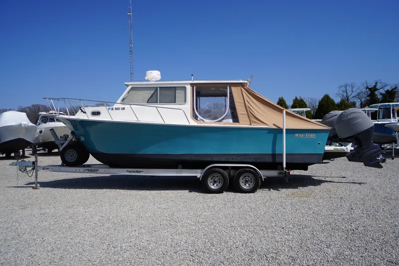 Slide: The Image of 2018 May-Craft 2700 Pilot XL boat on trailer, blue hull, parked on gravel. - 47