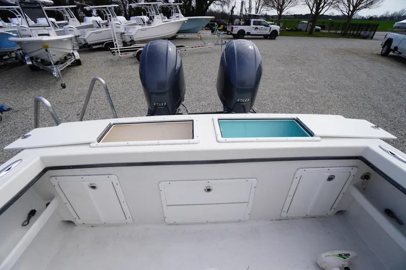 Slide: The Image of 2018 May-Craft 2700 Pilot XL boat with dual outboard motors in a gravel lot. - 8