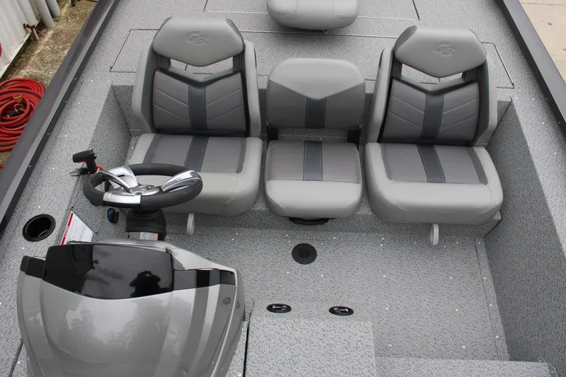 Slide: The Image of 2025 G3 Sportsman 1810 boat interior with gray seating and steering console. - 15