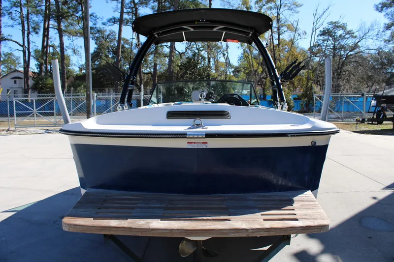 Slide: The Image of 1985 Correct Craft Ski Nautique boat, blue and white, parked outdoors. - 5