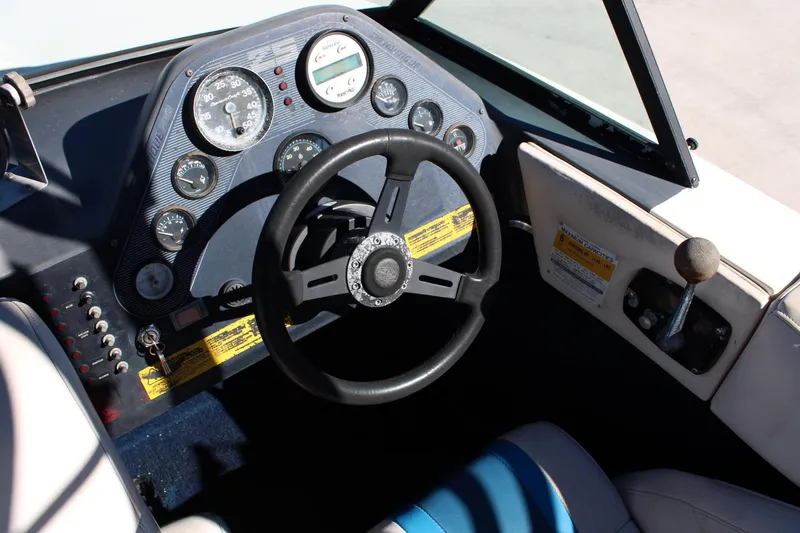 Slide: The Image of 1985 Correct Craft Ski Nautique dashboard with steering wheel and control panel. - 9