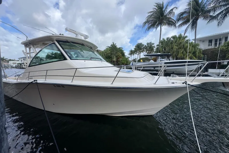 The Image of 2016 Grady-White Express 370 boat docked near palm trees and waterfront homes. - 0