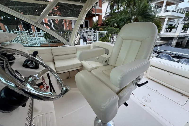 Slide: The Image of Luxury helm seating on 2016 Grady-White Express 370 boat, featuring plush white upholstery. - 11