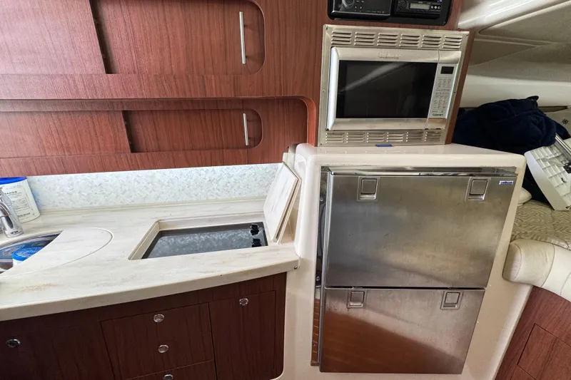 Slide: The Image of 2016 Grady-White Express 370 boat interior kitchen with microwave and stainless steel fridge. - 17