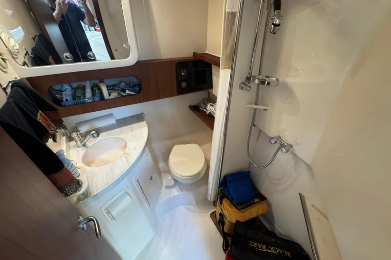 Slide: The Image of Bathroom interior of 2016 Grady-White Express 370 boat, featuring sink, toilet, and shower. - 26