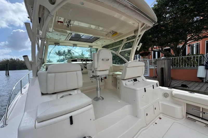Slide: The Image of 2016 Grady-White Express 370 boat interior with white seating and helm, docked by water. - 9