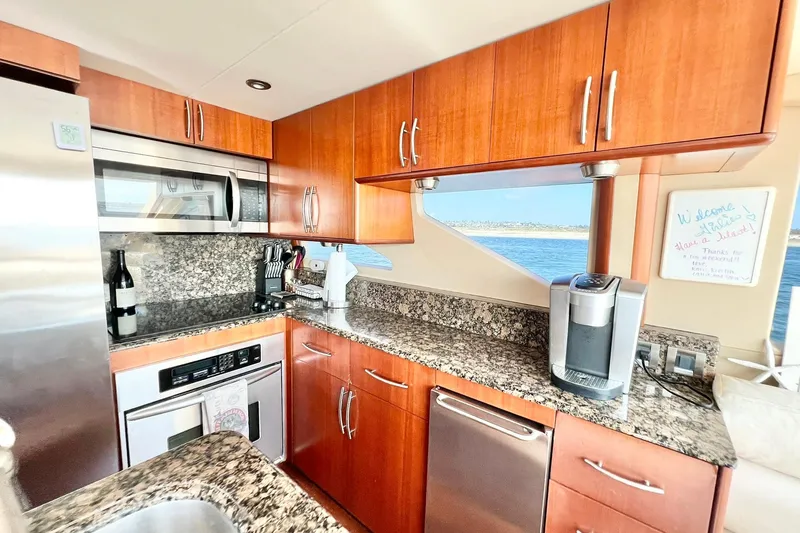 Slide: The Image of Luxurious kitchen interior of 2007 Lazzara 68 yacht with granite countertops and wooden cabinets. - 19