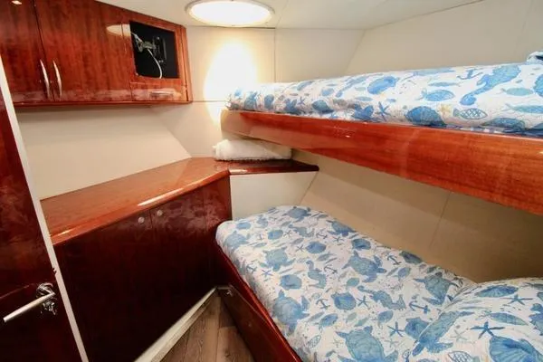 Slide: The Image of Cozy cabin with bunk beds in 2007 Lazzara 68 yacht, featuring wooden cabinetry and nautical-themed bedding. - 22