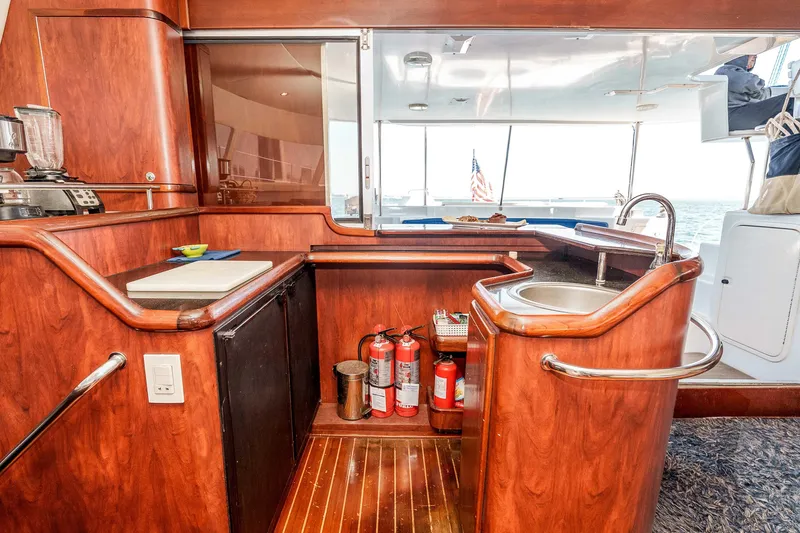 Slide: The Image of Luxurious 2009 Kelsall KSS 58 yacht interior with wooden cabinetry and compact kitchen area. - 21