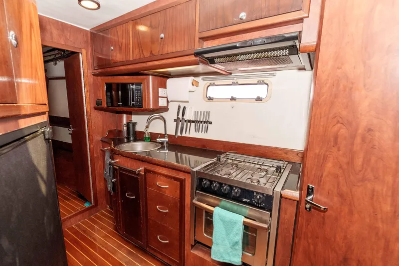 Slide: The Image of Galley kitchen in 2009 Kelsall KSS 58 yacht with wooden cabinetry and stainless steel appliances. - 24