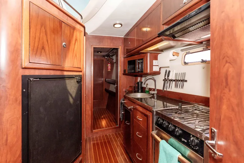 Slide: The Image of Luxurious 2009 Kelsall KSS 58 yacht kitchen with wood cabinetry and modern appliances. - 25
