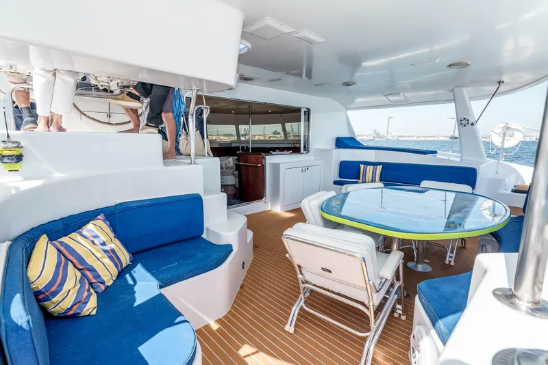 Slide: The Image of Spacious deck of 2009 Kelsall KSS 58 catamaran with blue seating and glass table. - 8