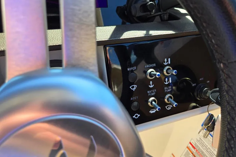 Slide: The Image of Control panel of a 2019 Sea Ray SDX 270 Outboard boat with switches and steering wheel. - 11