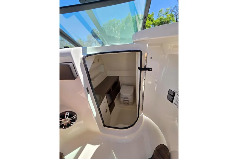 Slide: The Image of Interior view of 2019 Sea Ray SDX 270 Outboard boat cabin with toilet and storage. - 13