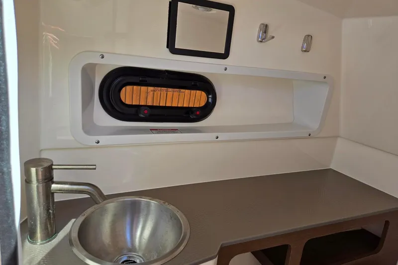 Slide: The Image of 2019 Sea Ray SDX 270 Outboard interior with sink and porthole window. - 15