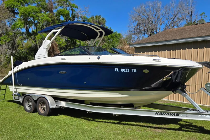 Slide: The Image of 2019 Sea Ray SDX 270 Outboard boat on trailer, parked on grass. - 21