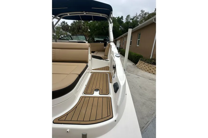 Slide: The Image of 2019 Sea Ray SDX 270 Outboard boat interior with tan seating and teak-style flooring. - 23