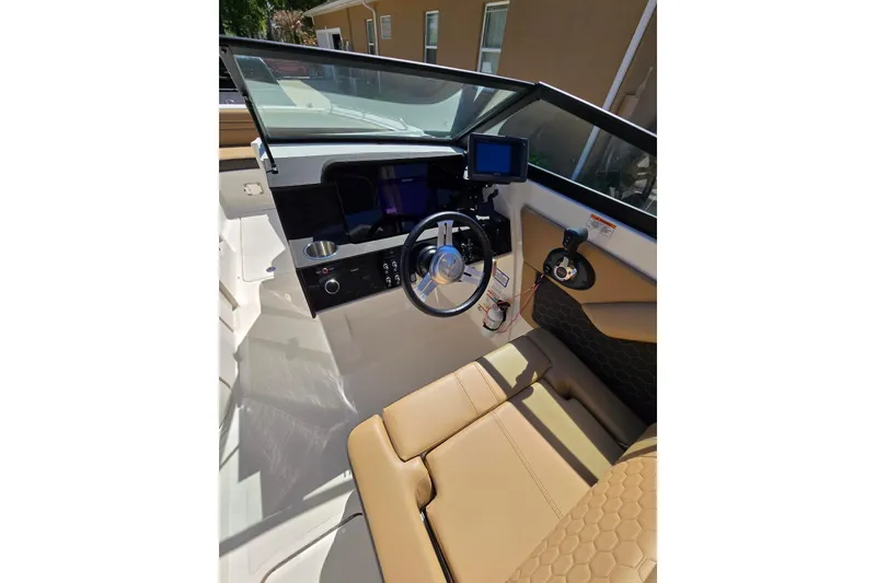 Slide: The Image of 2019 Sea Ray SDX 270 Outboard helm with tan seating and modern controls. - 9