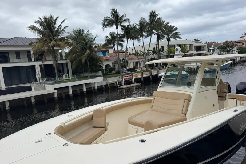 Slide: The Image of 2019 Scout 300 LXF boat docked by waterfront homes with palm trees. - 13