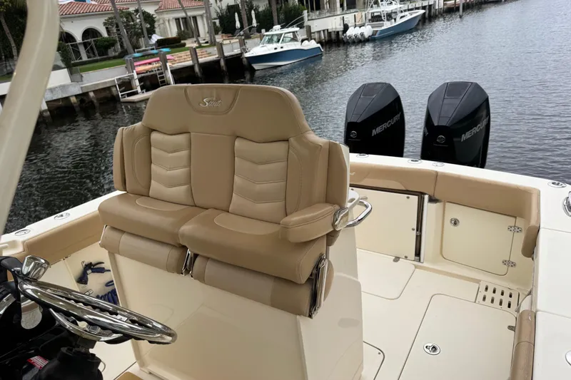Slide: The Image of 2019 Scout 300 LXF boat interior with tan seating and dual Mercury engines. - 7