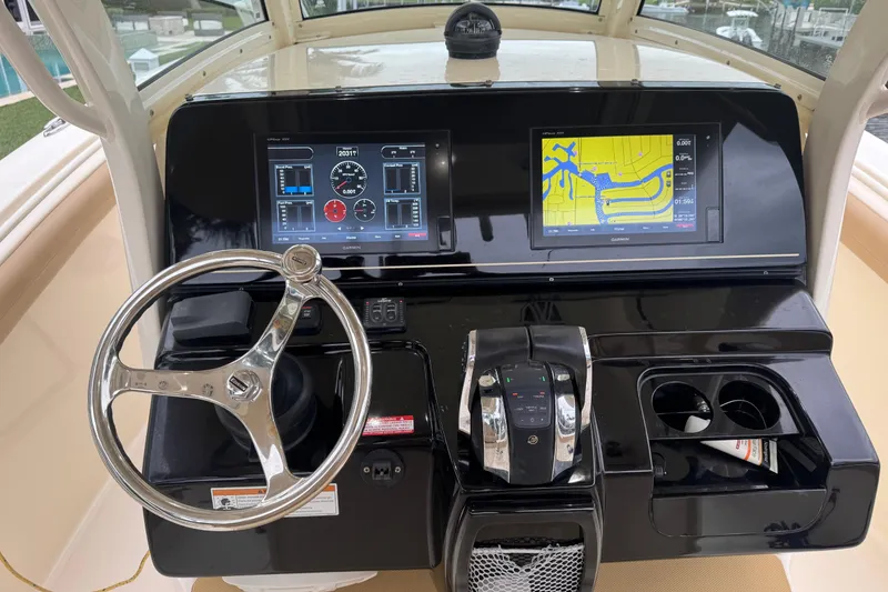 Slide: The Image of 2019 Scout 300 LXF boat dashboard with dual navigation screens and steering wheel. - 9