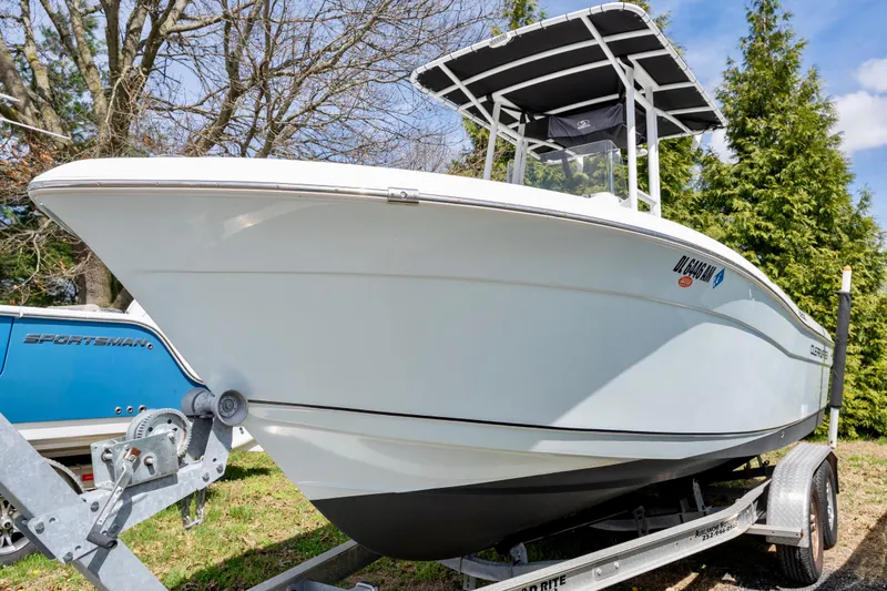 The Image of 2020 Clearwater 2200 boat on trailer, parked outdoors with trees in background. - 1