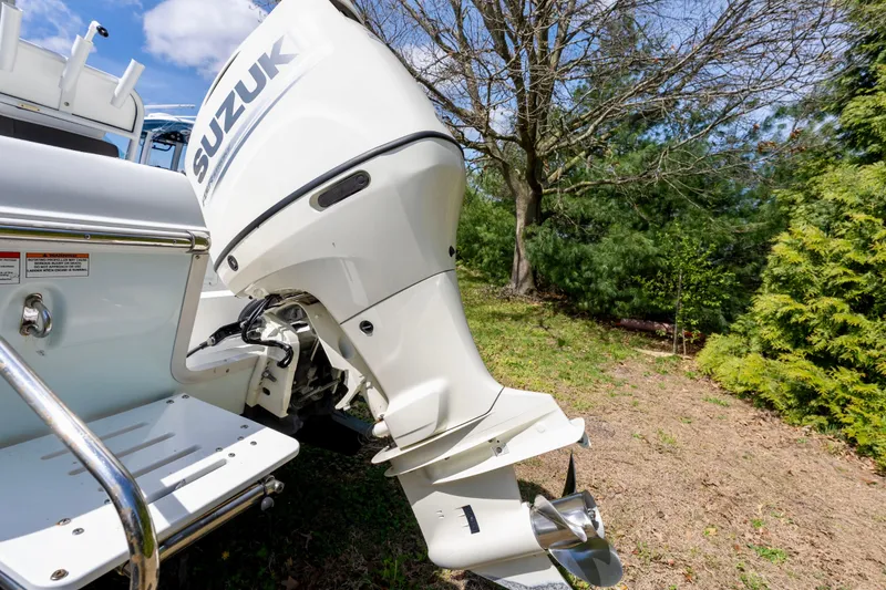 Slide: The Image of Outboard motor on a 2020 Clearwater 2200 boat, featuring a Suzuki engine, in a grassy area. - 14
