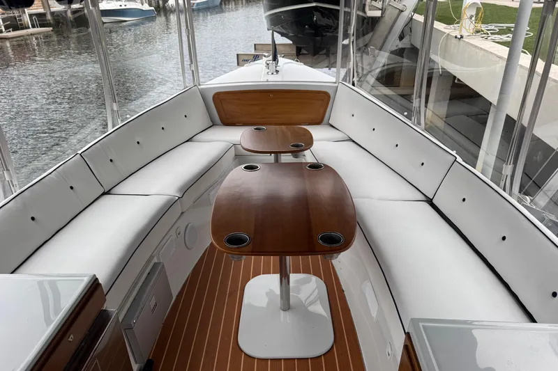 Slide: The Image of 2023 Duffy Bay Island 22 boat interior with white seating and wooden tables. - 13