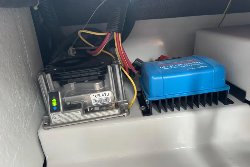 Slide: The Image of Electrical components inside a 2023 Duffy Bay Island 22 boat, featuring wiring and devices. - 16