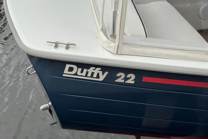 Slide: The Image of 2023 Duffy Bay Island 22 boat, blue hull with red stripe, docked on water. - 4