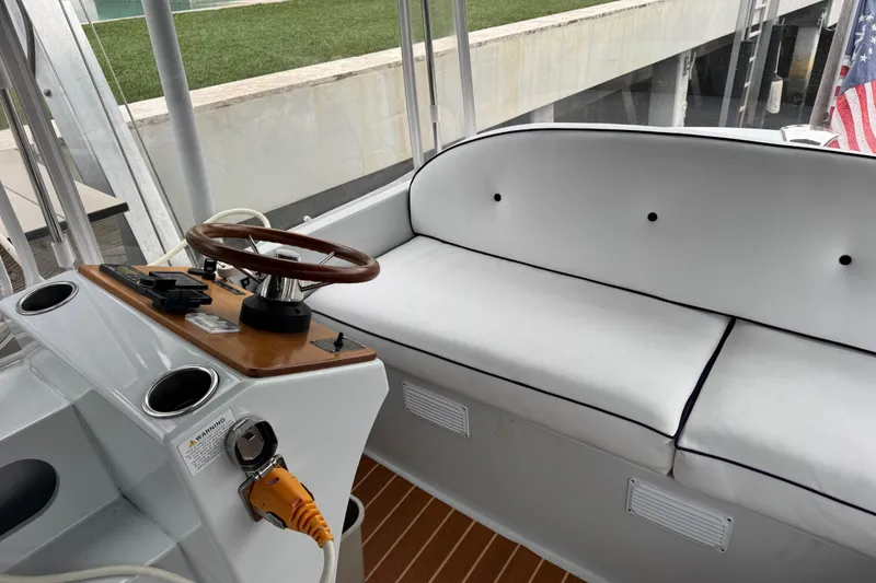 Slide: The Image of Interior of 2023 Duffy Bay Island 22 boat with steering wheel and cushioned seating. - 8