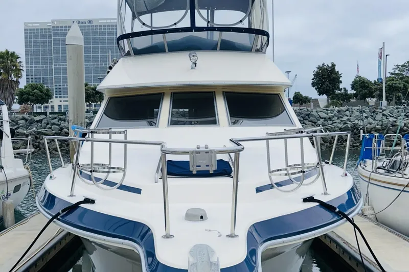 Slide: The Image of 1988 Sea Ray 265 Sedan Bridge docked at marina, front view. - 4