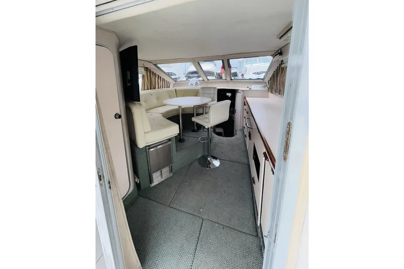 Slide: The Image of Interior of 1988 Sea Ray 265 Sedan Bridge, featuring seating and dining area. - 9