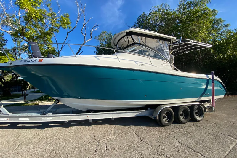 The Image of 2009 Century 3200 Offshore boat on trailer, parked outdoors under clear blue sky. - 0