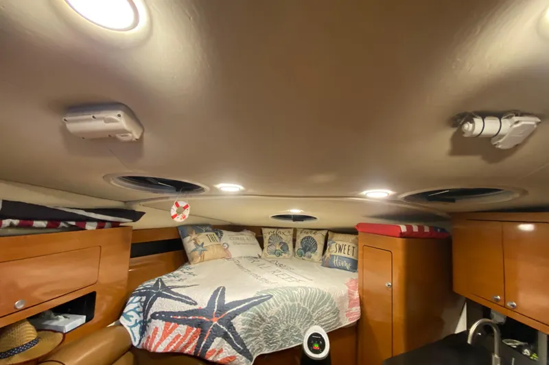 Slide: The Image of Cozy cabin interior of 2009 Century 3200 Offshore with nautical-themed bedding and wooden cabinets. - 27