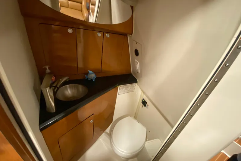 Slide: The Image of 2009 Century 3200 Offshore boat bathroom with sink, toilet, and wooden cabinetry. - 29