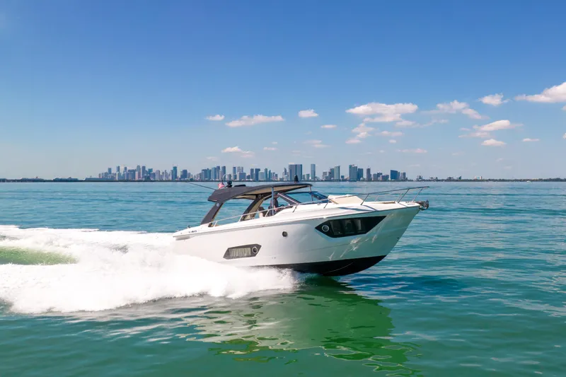 The Image of 2017 Absolute 40 STL yacht cruising on blue water with city skyline in background. - 0
