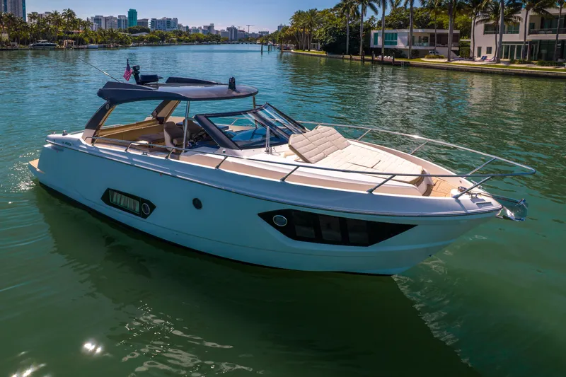 Slide: The Image of 2017 Absolute 40 STL yacht cruising on a sunny waterfront with palm trees. - 6