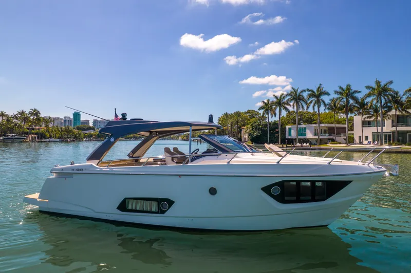 Slide: The Image of 2017 Absolute 40 STL yacht on serene water with palm trees and clear sky. - 67