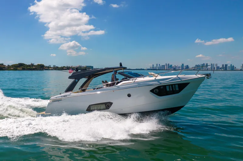 Slide: The Image of 2017 Absolute 40 STL yacht cruising on blue water with city skyline backdrop. - 77
